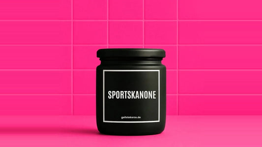 Duftkerze im Glas mit dem Aufdruck SPORTSKANONE, vor einer pinken Fliesenwand
