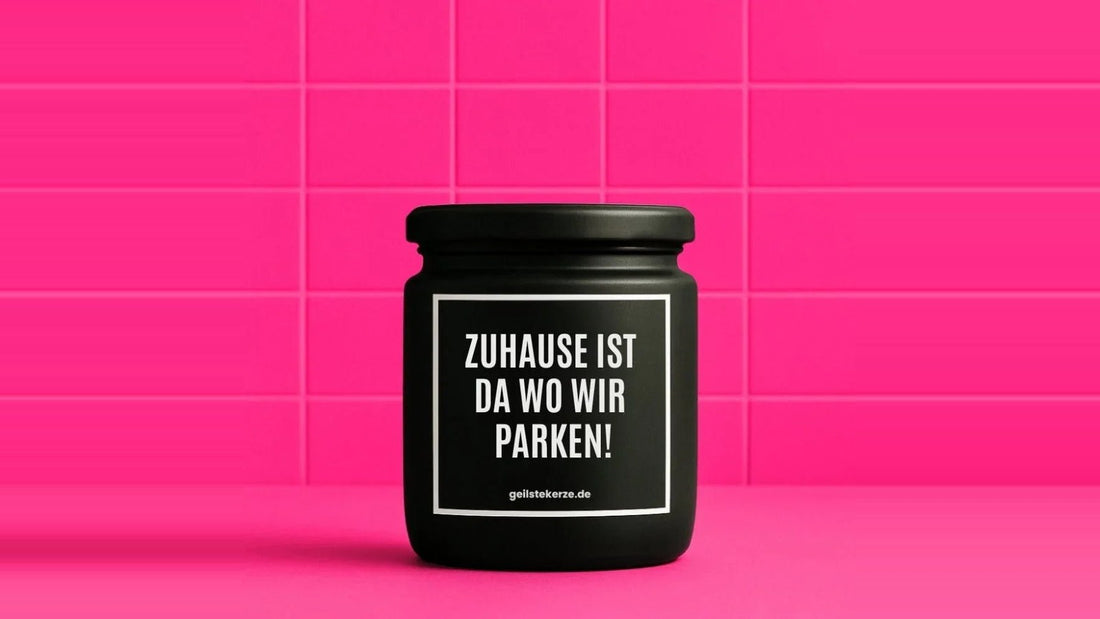 Duftkerze im Glas mit dem Aufdruck ZUHAUSE IST DA WO WIR PARKEN, vor einer pinken Fliesenwand