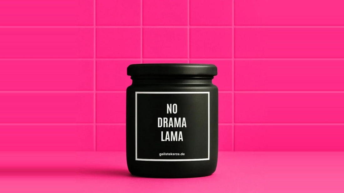 Duftkerze im Glas mit dem Aufdruck NO DRAMA LAMA, vor einer pinken Fliesenwand