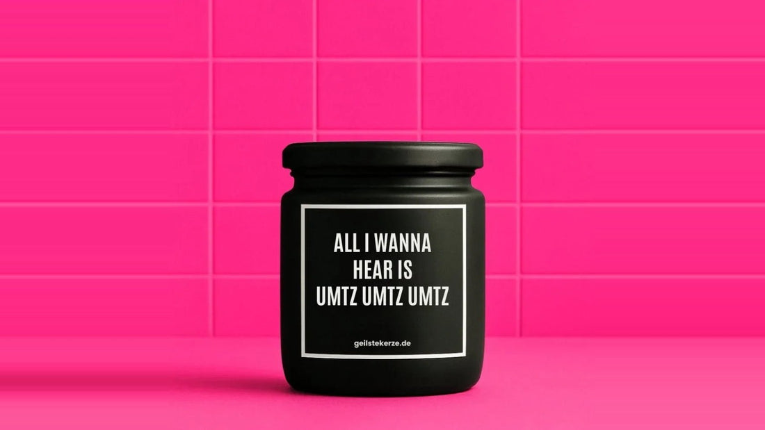 Schwarze Duftkerze im Glas mit dem Aufdruck ALL I WANNA HEAR IS UMTZ UMTZ UMTZ vor einer pinken Fliesenwand