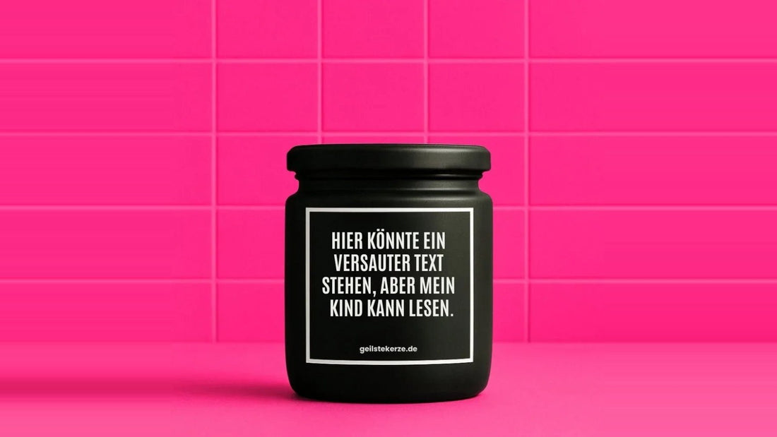 Duftkerze im Glas mit dem Aufdruck HIER KÖNNTE EIN VERSAUTER SPRUCH STEHEN, ABER MEIN KIND KANN LESEN, vor einer pinken Fliesenwand
