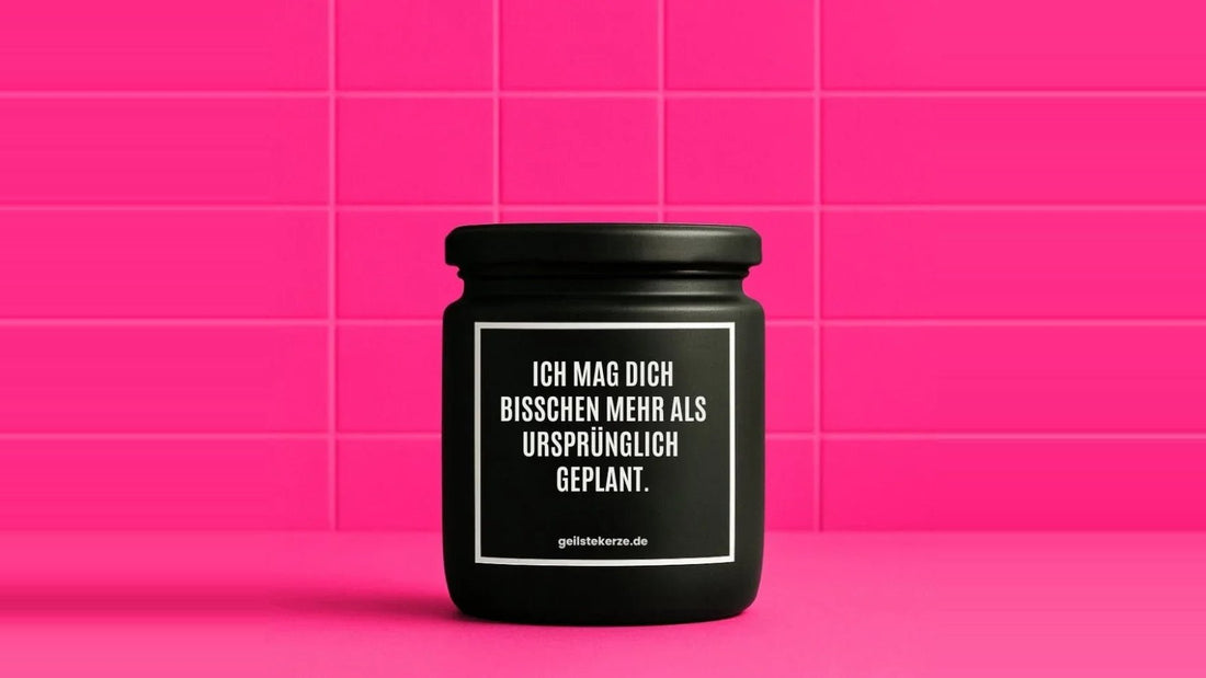 Duftkerze im Glas mit dem Aufdruck ICH MAG DICH BISSCHEN MEHR ALS URSPRÜNGLICH GEPLANT, vor einer pinken Fliesenwand