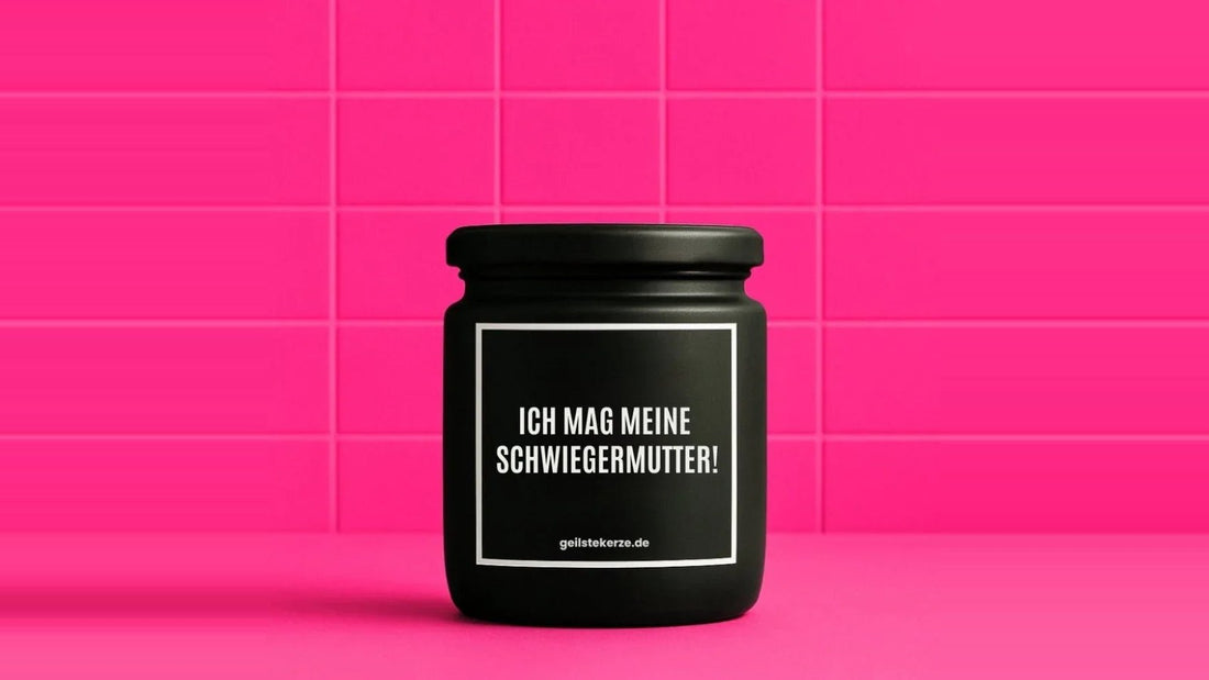 Duftkerze im Glas mit dem Aufdruck ICH MAG MEINE SCHWIEGERMUTTER, vor einer pinken Fliesenwand