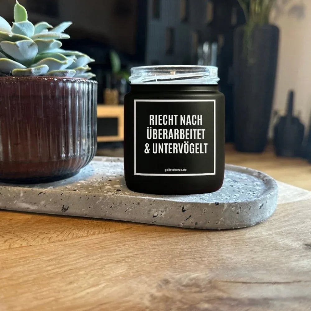 Duftkerze mit Spruch von geilstekerze ist der neue Geschenketrend. Diese witzige Kerze Vegane Bio-Kerze mit Spruch – RIECHT NACH ÜBERARBEITET UND UNTERVÖGELT brennt mega lange sagenhafte 80 Stunde, hochwertige ätherische Öle schaffen beste Duftverteilung. Mit 1400 lustigen Sprüchen perfekt zum Verschenken. Handgemacht in Deutschland von geilstekerze.de -Die beste Duftkerze die du kaufen kannst.